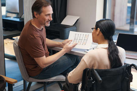 Man with female colleague with disability working together