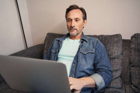 Mature man working on laptop at home