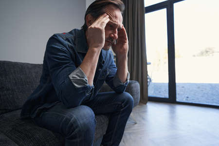Mature man feeling sad while staying at homeの写真素材