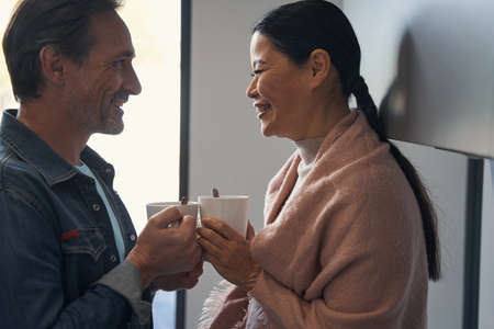Happy aged couple drinking coffee at home
