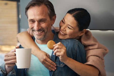 Happy mature couple enjoying breakfast together at home