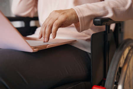 Woman with paraleria using notebook at homeの写真素材