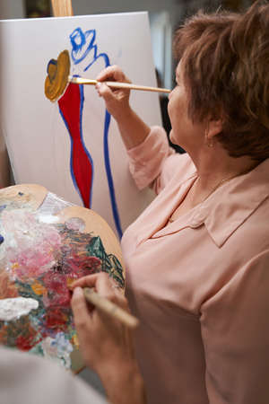 Close up of brunette woman drawing female on abstract pictureの写真素材