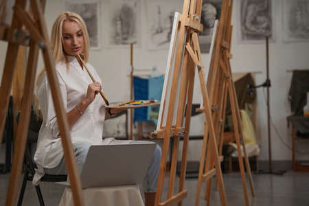 Pleased young artist taking idea from the internet