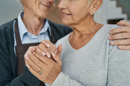 Focused photo of pleased man embracing his wifeの写真素材
