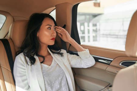 Seriously business lady is sitting in automobile