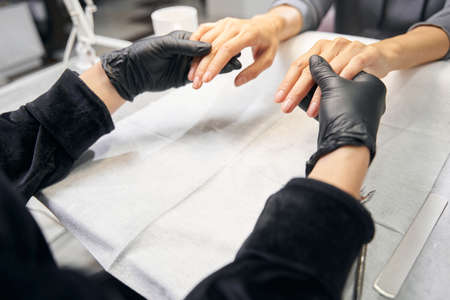 Elegant woman fingers above the white table in beauty centerの写真素材