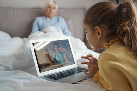 Young child learning about medicine online to help grandma recoverの写真素材