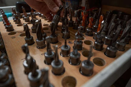 Close up of male hand taking drill bits