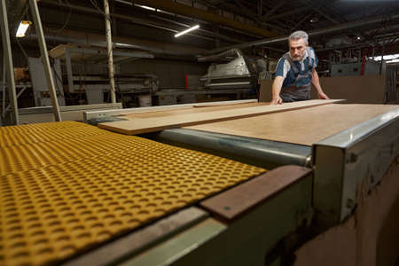 Focused photo on busy worker being at manufacture