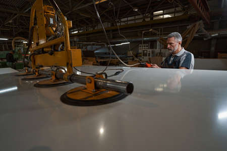Serious aged master testing new polishing equipment