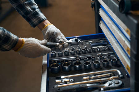 Skilled mechanic choosing needed tools for the jobの写真素材