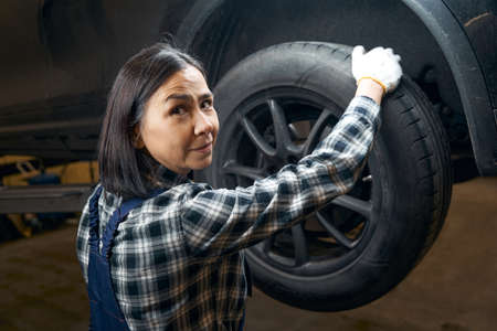 Professional repair shop worker posing with a tyreの写真素材