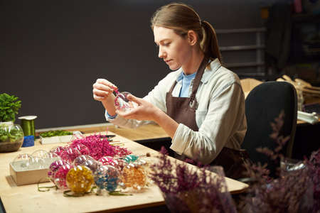 Young pretty woman is making handmade decorations