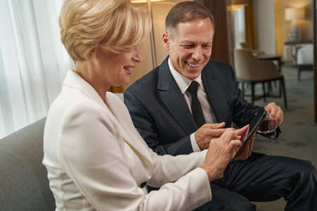 Business colleague reading information on phone during meeting in hotel room