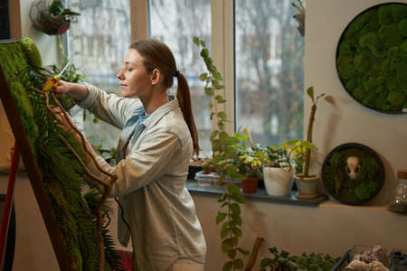 Creative woman making picture with green plants
