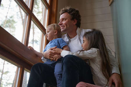 Close up of happy man embracing his children