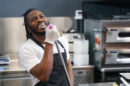 Happy man cleaning work place in restaurantの写真素材