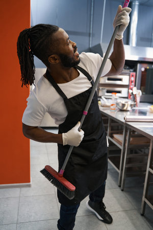 Funny chef cleaning floor at the restaurantの写真素材