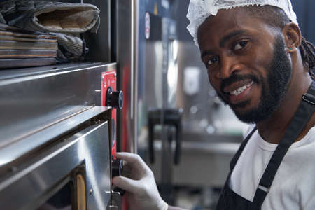 Male hard working, baking food in restaurantの写真素材