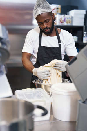 Man in protective clothes working at the kitchenの写真素材