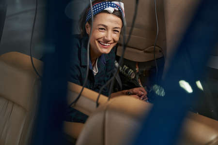 Happy positive woman mechanic smiling at the photo camera in airplaneの写真素材