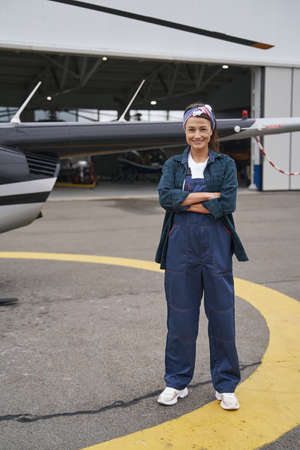 Woman engineer in overall posing in front of the hangarの写真素材