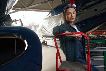 Beautiful elegant female relief engineer working in aviation hangarの写真素材
