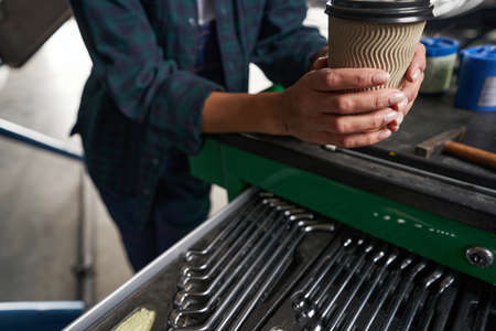 Unrecognized woman relief engineer resting during the break in the hangarの写真素材