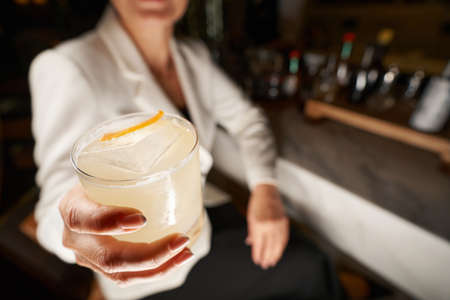 Fragment photo of delicious beverage in hand of bar visitorの写真素材