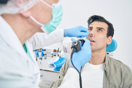 Otorhinolaryngologist working with medical instrument at the hospital