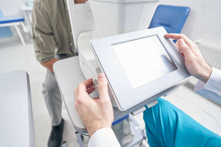 Doctor sitting at the medical machine and working