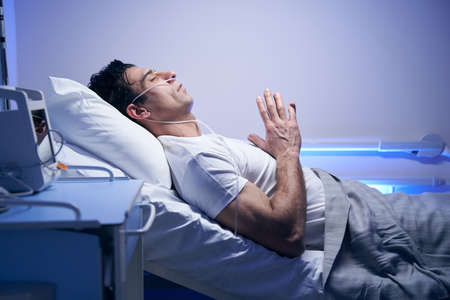 Man in white t-shirt resting after proceduresの写真素材