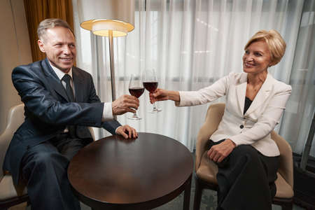 Business colleagues drinking wine at hotel room together