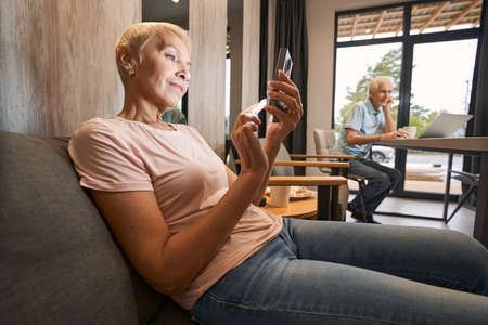 Pleased mature woman chatting with her friend