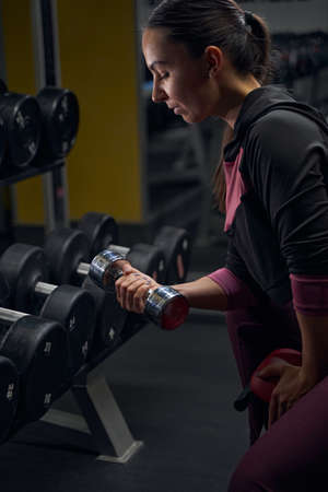 Profile photo of sportswoman looking at her hand