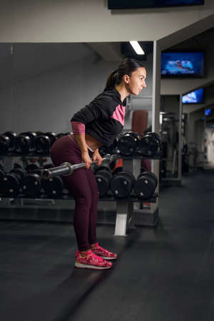 Concentrated athlete female person doing lifting exercise