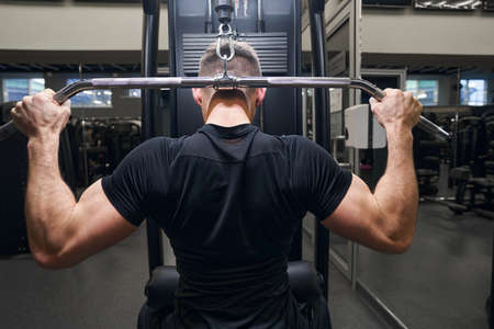 Back view of sporty man cultivating strong body