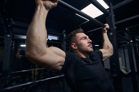 Strong athlete demonstrating power of his muscles