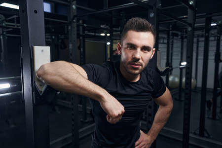 Strong athletic man looking straight at camera
