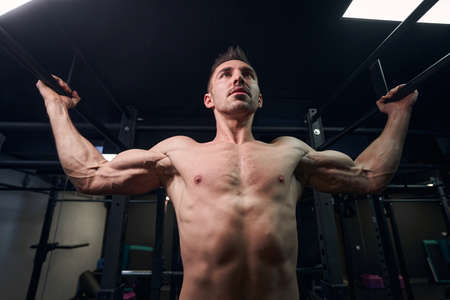Focused photo on athletic man doing physical training