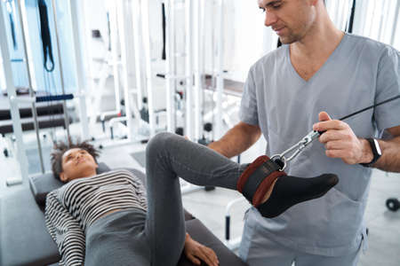 Young woman having rehabilitation in the gym