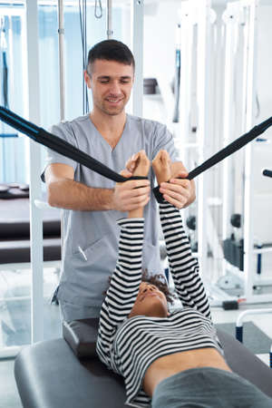 Lady having rehabilitation with doctor in the gym