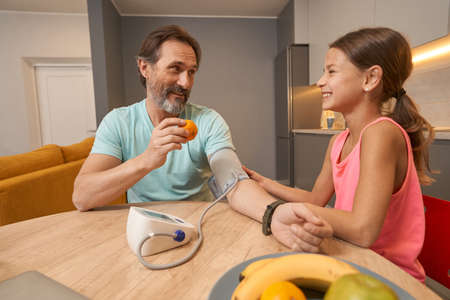 Girl siting at a table with a man and measure the pressure