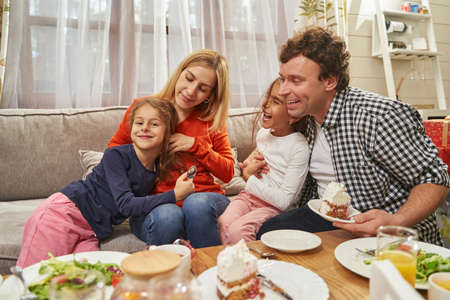 Portrait of happy parents and children eating cakeの写真素材
