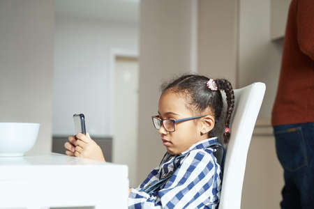 Close-up photo of African American girl playing on smartphoneの写真素材