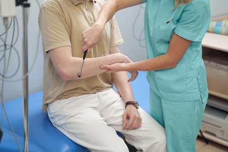 Female neurologist checking patient health with instrumentの写真素材