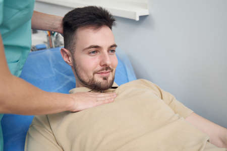 Smiling young male patient in medical officeの写真素材