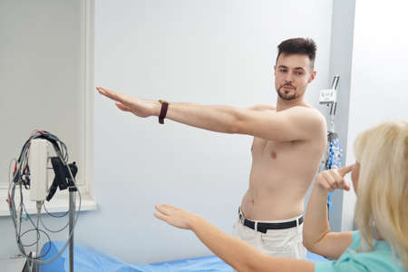 Cheerful topless man during examination in clinicの写真素材
