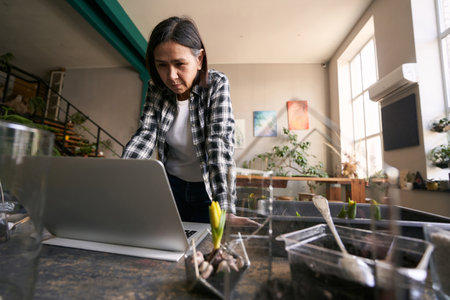 Adult lady working in studio on laptopの写真素材